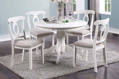 a white table with four chairs around it