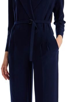 Made of comfortable poly lycra with laser-cut trims, this Norma Kamali jumpsuit boasts a surplice top that replicates a double-breasted jacket with peaked lapels, padded shoulders and an internal hook-and-loop closure. The waist is defined by front pleats and a matching D-ring belt, then falls into a pair of fluid, straight pants with side pockets. The model is 177 cm tall and wears a size XS. Composition: 95%PL, 5%EA Sleek V-neck Jumpsuits And Rompers For Work, Sleek Fall Workwear Jumpsuits And Rompers, Sleek Workwear Jumpsuits And Rompers For Fall, Sleek Jumpsuits And Rompers For Fall Workwear, Chic Workwear Jumpsuits And Rompers With Belted Cuffs, Belted Long Sleeve Jumpsuits For Work, Belted Long Sleeve Jumpsuits And Rompers For Work, Chic Jumpsuits And Rompers With Belted Cuffs For Work, Elegant Workwear Jumpsuits And Rompers For Fall