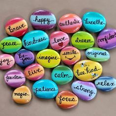 some colorful rocks with words written on them