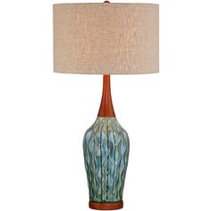 a table lamp with a brown base and a blue glass vase on the bottom that is holding a beige linen shade