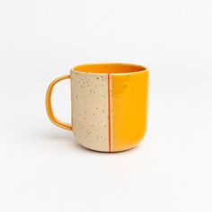 a yellow and white coffee cup sitting on top of a table