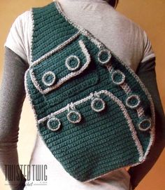 a woman wearing a green crocheted bag with eye glasses on it's back