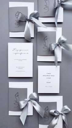 the wedding stationery is adorned with silver ribbon and bowknots, along with matching envelopes