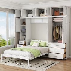 a white bed sitting under a window next to a book shelf