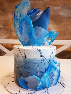 a blue and white cake sitting on top of a table