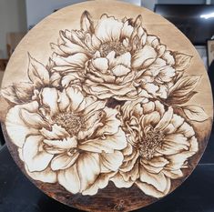 a wooden plate with flowers painted on it