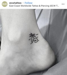 a small tattoo on the foot of a person with a palm tree in the background