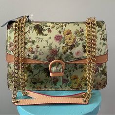 This Is A Cavalcanti Collection Brand Handbag That Is Brand New With Tags And Was Made In Italy. Bag Is Made Of Genuine Leather That Is Metallic Gold With A Colorful Floral Print. Has Vachetta Leather Accents On The Handles, The Front Of The Purse, The Front Buckle, The Sides, And The Bottom Of The Purse. Inside Of The Purse Has A Zippered Divider Pocket In The Middle And A Zippered Pocket At The Back Wall. Strap Is A Shiny Polished Goldtone Chain. Bag Is Brand New With Original Tags Attached An Elegant Leather Shoulder Bag With Floral Print, Elegant Multicolor Shoulder Bag With Adjustable Strap, Elegant Floral Print Bag For Everyday Use, Elegant Multicolor Bag With Adjustable Strap, Elegant Multicolor Crossbody Shoulder Bag, Elegant Multicolor Shoulder Bag With Detachable Strap, Chic Satchel With Floral Print, Elegant Multicolor Bags With Gold-tone Hardware, Chic Formal Bags With Floral Print