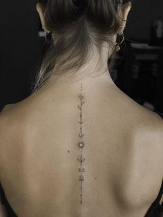 the back of a woman's neck with tattoos on her upper and lower back