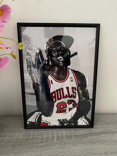 a framed photograph of a chicago bulls player holding a baseball bat and wearing a hat