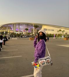 a woman walking across a parking lot holding onto a handbag in her right hand