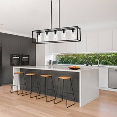 a modern kitchen with an island and bar stools