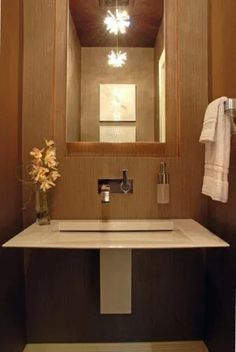 a bathroom sink sitting under a mirror next to a towel rack with flowers on it