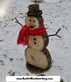 a snowman made out of wood with a red scarf around it's neck