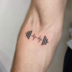 a man's arm with a heartbeat tattoo on it