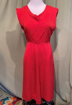 This is a cute vintage dress from the 40s or early 50s.  Labeled Maisonette Frocks. No size tags. The bust measures 34", waist 24", hip 36", see measurements below.  Made of red cotton blend. The dress is not lined.  It has a slight cap style sleeve, just an extension of the shoulder really. The neckline is a wide boat style with a small V center front. Seamed at the waist with a slightly flared skirt, it has slip pockets on the side seams. Buttons up the back with red, flower shaped buttons.  The dress is in very good condition, no wear or tear.  No damage but it does have several small rust color spots at the neckline & on the skirt which are hard to see, please see photos for details Measurements were taken with the garment lying flat & the bust, hip & waist measurements were doubled fo Retro Solid A-line Vintage Dress, Solid Color A-line Retro Vintage Dress, Solid Color Retro A-line Vintage Dress, Red Vintage Midi Dress, Solid Vintage A-line Midi Dress, Vintage Red Sleeveless Midi Dress, Sleeveless Red Vintage Dress, Solid A-line Vintage Midi Dress, Red Sleeveless Vintage Dress