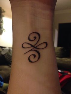 a tattoo on the wrist of a woman with an infinite symbol tattooed on her left arm