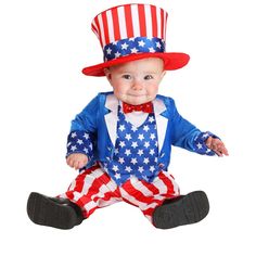 a baby dressed up in an american flag outfit and top hat sitting on the ground