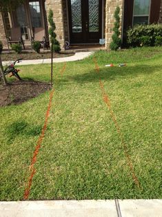 an orange line on the grass in front of a house