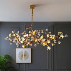 a chandelier hanging from the ceiling in a room with grey walls and furniture