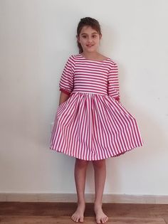 Pink and white striped dress A lovely summer dress for stylish girls in pink and white striped cotton. The dress features short sleeves, pockets and an open back that closes with buttons. This handmade beautiful dress is perfect for any occasion. Available in sizes 12-12 years. *Actual color may vary from picture due to computer settings. *Care You can use it, love it and throw it in the washing machine when necessary. My dresses are totally handmade to a high standard. Please feel free to browse other dresses in my shop or contact me for custom orders. Dresses can be gift wrapped with a special message free of charge, just let me know in the 'notes to seller' when you check out. Join our Facebook page or follow our Instagram to be the first to hear about new designs and exclusive offers. White Open Back Dress, Dark Blue Velvet Dress, Velvet Christmas Dress, Striped Summer Dress, Horse Dress, Island Dress, Striped Dress Summer, Turquoise Dress, Floral Robes