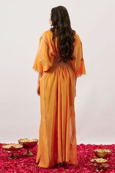 Orange kimono sleeves kaftan with delicate zari dori stripe highlights and sheer hem detailing. - Aza Fashions Bohemian Cotton Silk Dress With Traditional Drape, Traditional Kimono With Tassels, Bohemian Wedding Kaftan With Cutdana, Bohemian Cutdana Kaftan For Festivals, Traditional Kurta With Back Tassel Tie-up For Diwali, Festive Dress With Kimono Sleeves, Traditional Tunic With Kimono Sleeves, Bohemian Chanderi Kaftan For Festive Occasions, Bohemian Chanderi Kaftan For Navratri