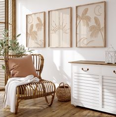 a room with white walls and wooden flooring is furnished with rattan chairs, wicker side tables, and artwork on the wall