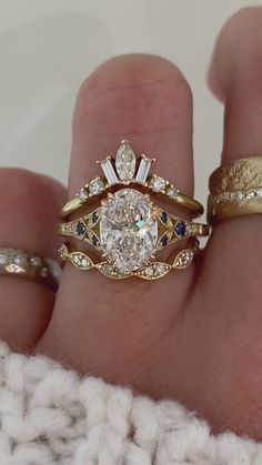 a woman's hand with two gold rings and one diamond ring on her finger