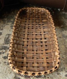 a woven basket sitting on top of a stone floor