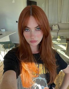 a woman with long red hair is taking a selfie