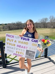 a woman holding a sign that says pack up your car put a hand on your heart and whatever you feel prom