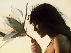 a woman holding a flower in her right hand