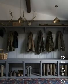 the coat rack has many coats hanging on it's hooks, and there is also a rug