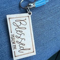 a wooden keychain with a name tag hanging from it's back end