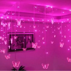 pink lights hanging from the ceiling in a room with butterflies on it and a mirror