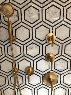 a shower head and hand shower in a bathroom with hexagonal tiles on the wall