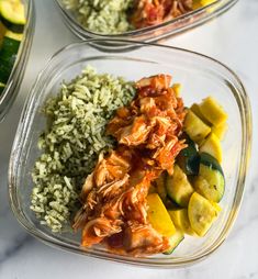 two glass bowls filled with rice, meat and veggies next to cucumbers