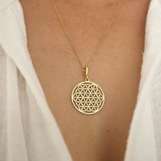 This elegant gold necklace features the "Flower of Life" motif, one of the most well-known symbols in the world of sacred geometry. The Flower of Life symbolizes the fundamental building blocks of the universe, its mathematical order and the unity of life. This symbol is associated with energy, protection and growth in spiritual and metaphysical fields. This necklace, which you can wear both in daily life and on special occasions, offers a combination of spiritual and aesthetic values. Why Choos 14k Gold Medallion Necklace In Spiritual Style, Yellow Gold Medallion Necklace With Si Clarity, Symbolic 14k Gold Necklaces, Symbolic 14k Gold Star Of David Jewelry, Symbolic 14k Gold Necklace, Sterling Silver 14k Stamped Amulet Jewelry, Spiritual Gold Necklaces With Diamond Cut, Symbolic Diamond Cut Jewelry Gift, Gold Engraved Star Of David Necklace