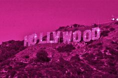 the hollywood sign is lit up in pink and purple colors on top of a hill