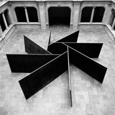 black and white photograph of an art installation in the middle of a building with columns