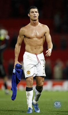 a shirtless man walking on a soccer field