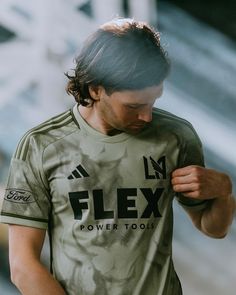 a man with long hair wearing a shirt that says flex power tools on the front