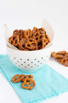 a bowl filled with pretzels sitting on top of a blue napkin