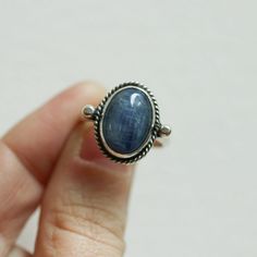 We are very excited about the look and feel of our new Deep Blue Kyanite Lasso Ring! This Boho Blue Kyanite Ring looks and feels great - you won't want to take it off! Perfectly balanced with a healthy sized 10X14mm Blue Kyanite stone, .925 Sterling silver accents and half-round shank - super comfortable and easy to wear. This ring's all sterling silver details are unique and truly set off the stone! You might want to make room on your hand -- you're going to want to wear this Blue Kyanite State Sapphire Cabochon Rings For Gifts, Everyday Sapphire Ring Jewelry, Untreated Oval Sapphire Ring For Gift, Untreated Oval Sapphire Ring As Gift, Blue Rings With Large Stone For Healing, Handmade Oval Sapphire Rings, Everyday Blue Sapphire Ring, Blue Untreated Oval Rings, Everyday Sapphire Ring