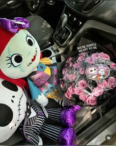 there is a stuffed animal in the back seat of a car with flowers and candy