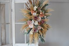 an arrangement of dried flowers in a vase