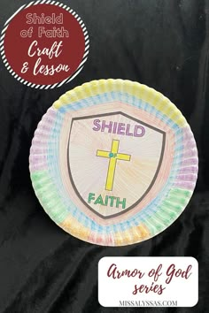 a paper plate with the words shield and faith on it, in front of a black background