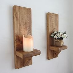 two wooden shelves with candles and flowers on them