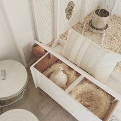 a white bench with two open compartments on the bottom and one filled with hay in it