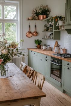 a kitchen with green cabinets and wooden table